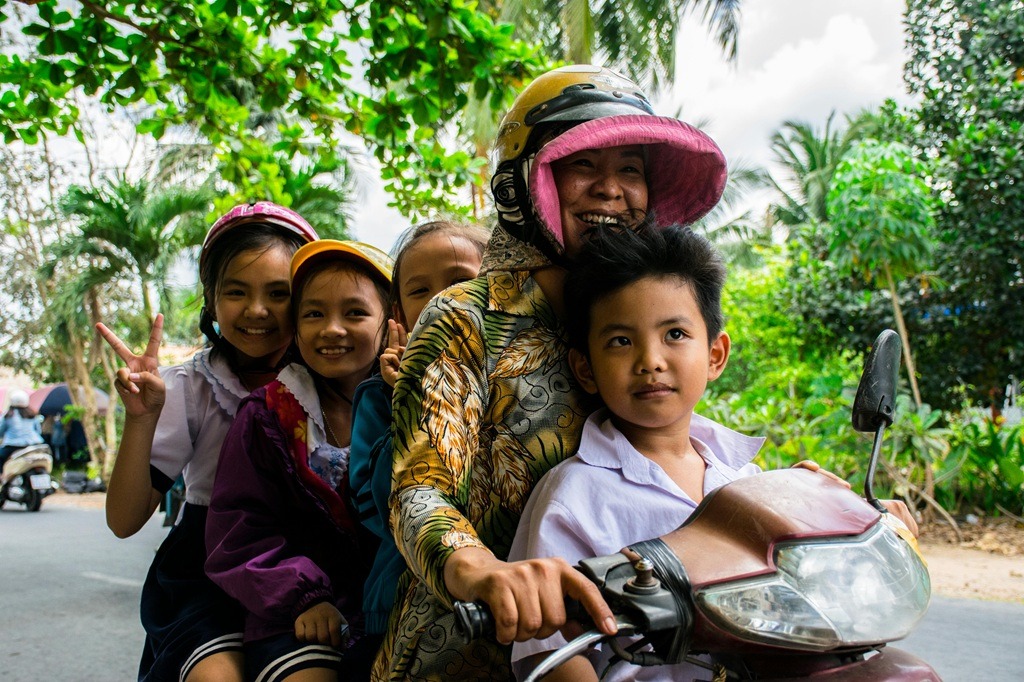 Motorcycles South Africa 2026 - Group of smiling children on a motorcycle ride through Ho Chi Minh City, capturing happiness and innocence